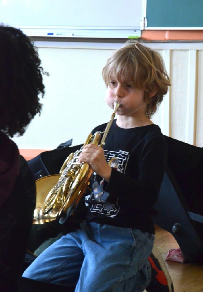 Jeune garçon soufflant dans un cor