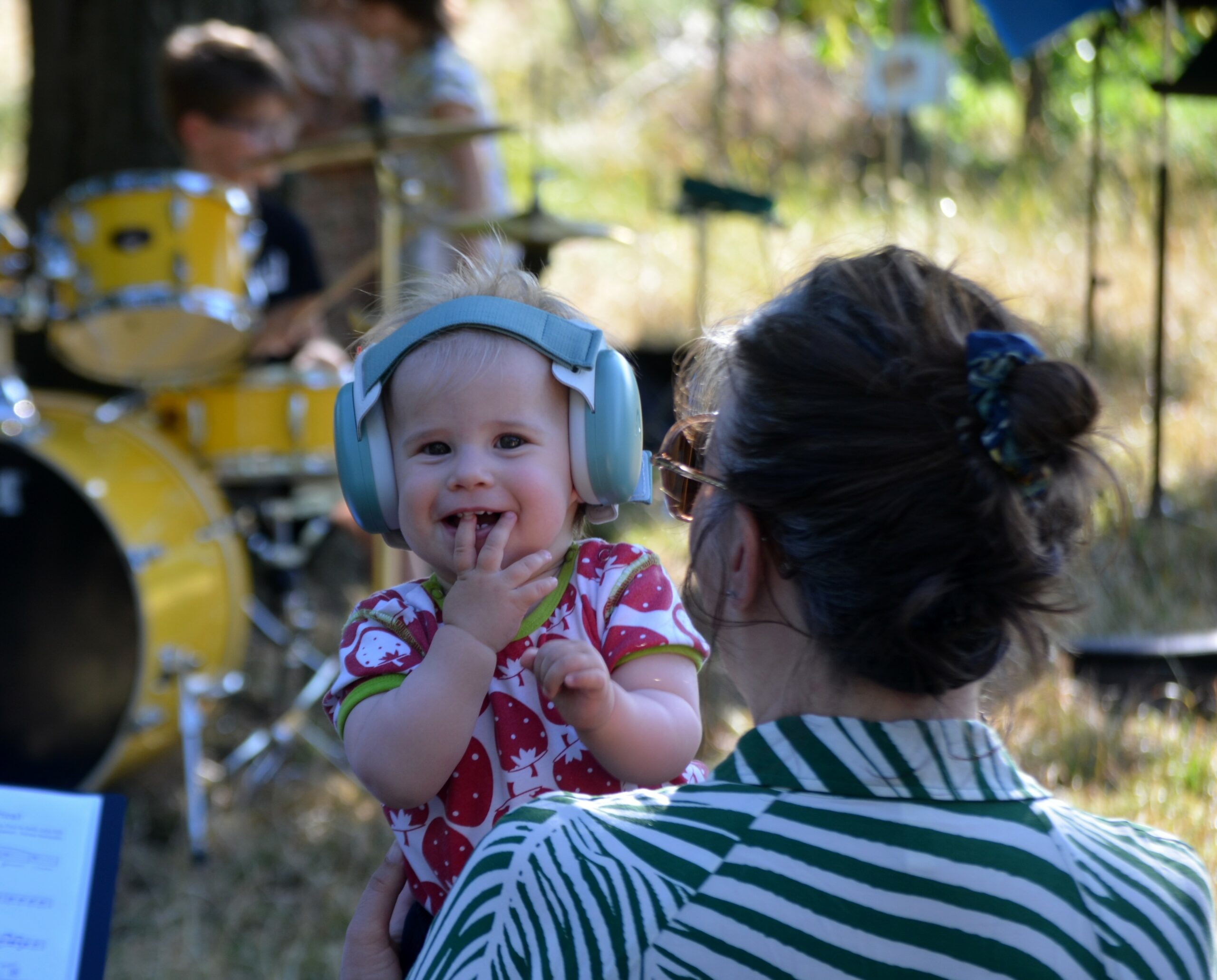Une très jeune auditrice avec un casque anti-bruit pendant le concert de batterie